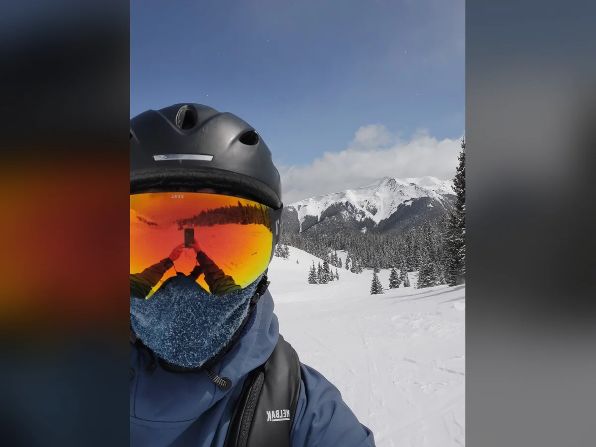 A skier taking a selfie in the snowy mountains