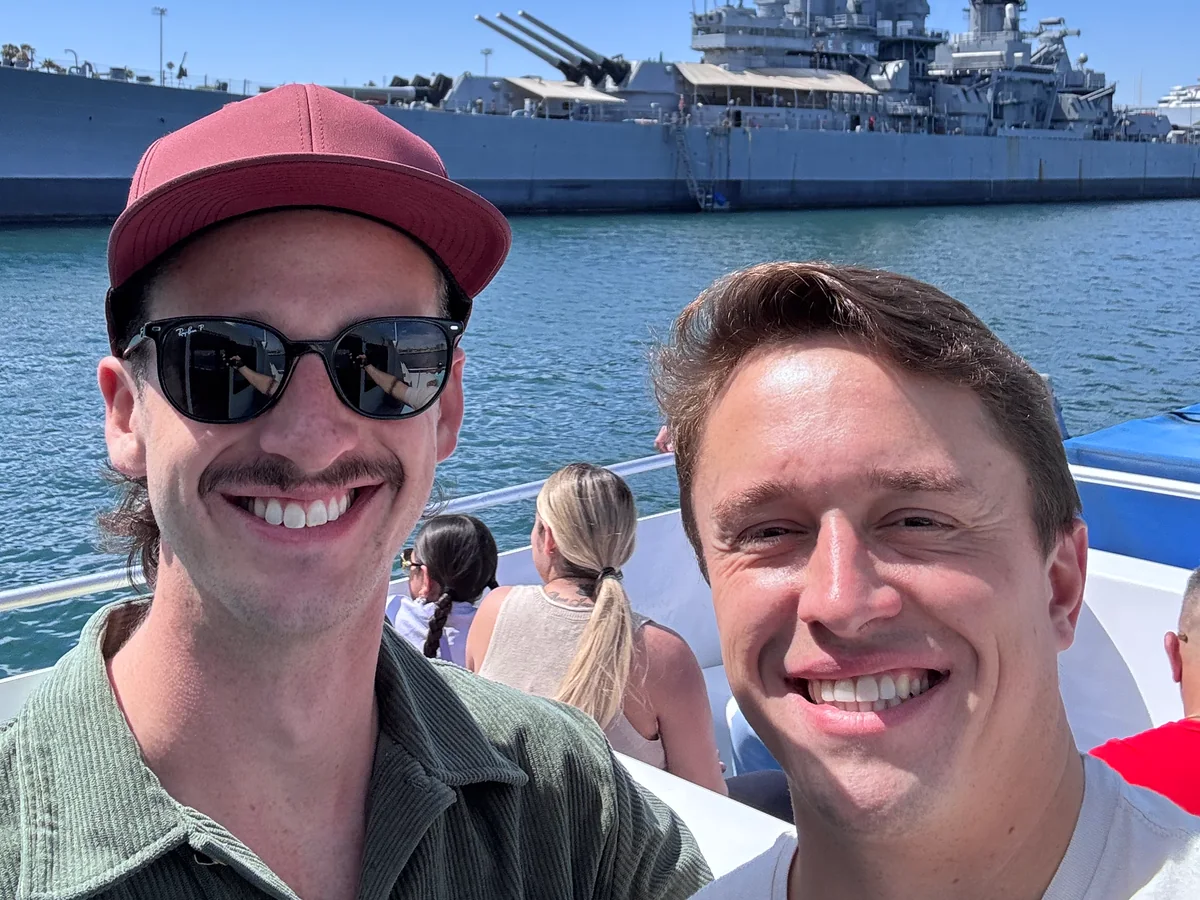 A waterfront selfie with a historic ship in the background