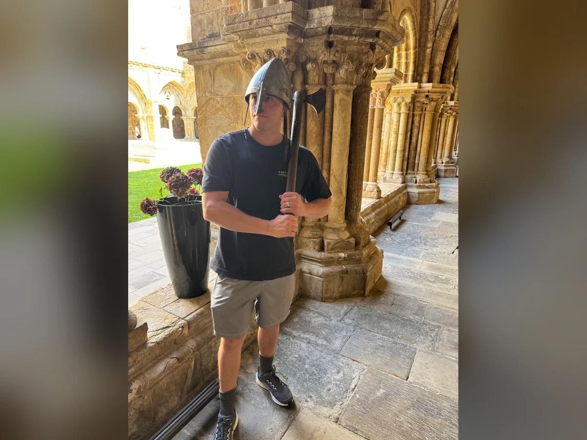 Trying on a helmet while exploring a historic stone courtyard